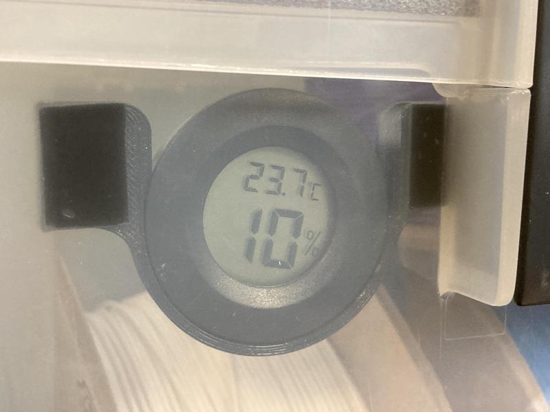 Drop-in holder for round humidity/temperature gauge in a drybox
