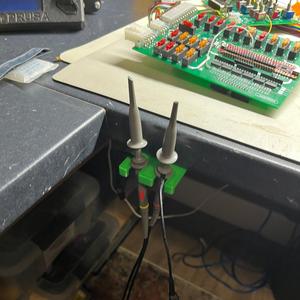 Retractable under-bench scope/voltmeter probe holder