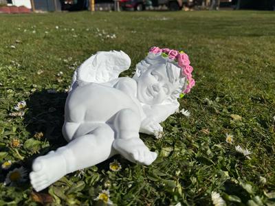 Reclining angel with floral wreath