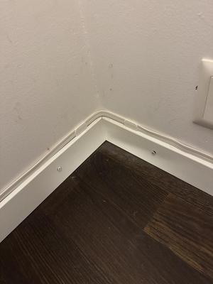 Cable holder for flat speaker cable on top of skirting board