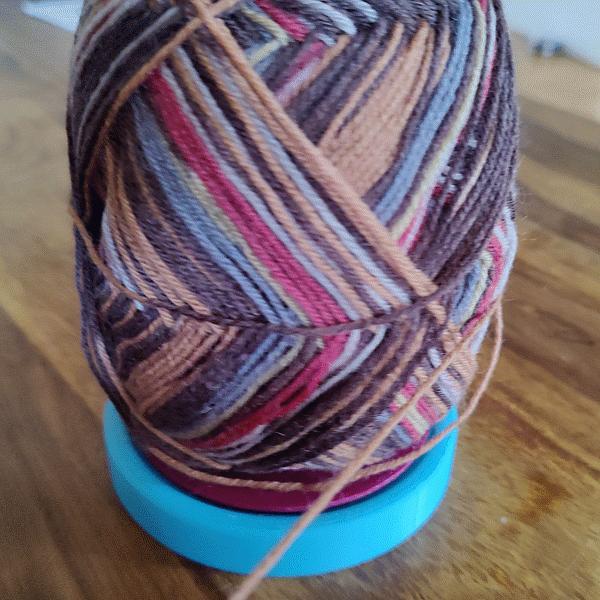 Yarn ball holder with ball bearing knitting gadget