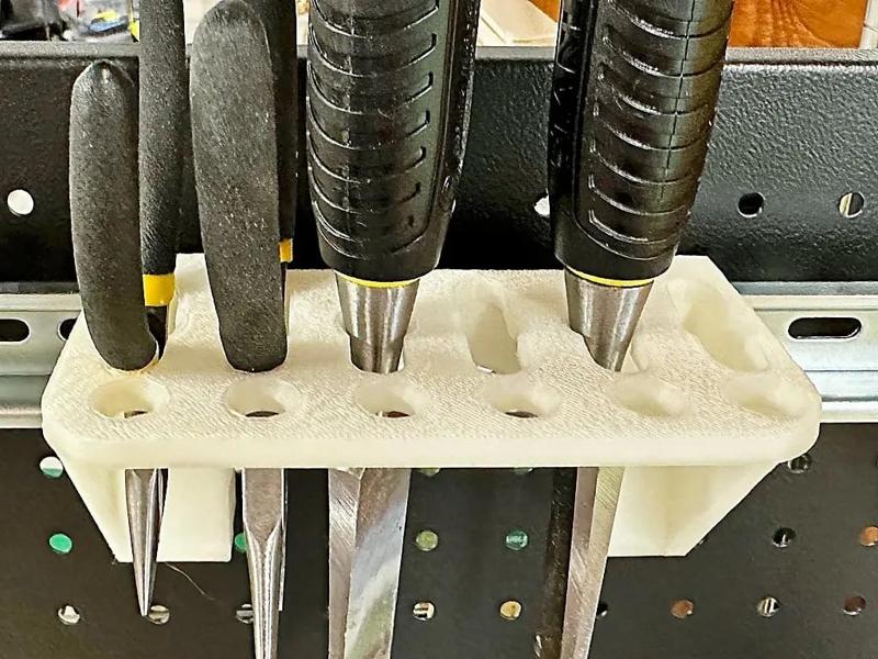 A DIN rail mounting bracket to hold chisels, pliers, scissors, and other such things   