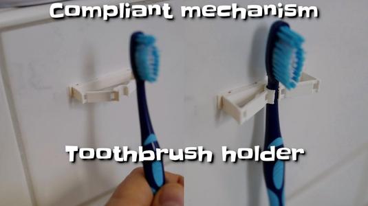Compliant mechanism toothbrush holder 